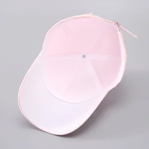 Inside view of pink baseball cap showing six-panel stitching and adjustable metal buckle strap