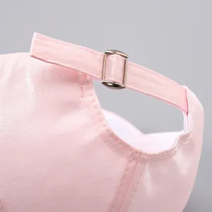 Detail of pink baseball cap with adjustable silver buckle and metallic fabric texture