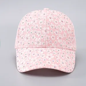 Detail of pink floral lace baseball cap with sparkling colorful rhinestones and curved brim