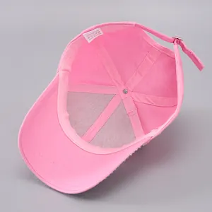 Détail intérieur d'une casquette rose en coton avec strass et étiquette d'entretien