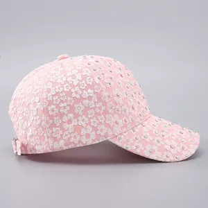 Detail showing pink floral lace texture and colorful rhinestones on a women baseball cap