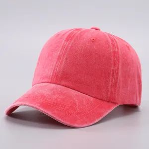Close-up of red washed cotton baseball cap featuring vintage distressed fabric and stitching