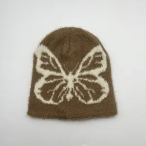 Dettaglio del motivo jacquard a farfalla e texture soffice sul berretto marrone