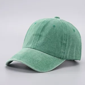 Close-up of a washed cotton baseball cap in green with reinforced visor stitching