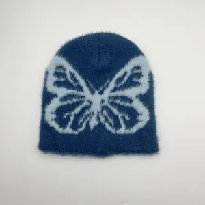 Dettaglio della trama in peluche di un berretto blu navy con jacquard a farfalla grande