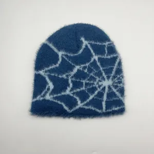 Détail du bonnet en tricot bleu avec motif jacquard de toile d'araignée blanche