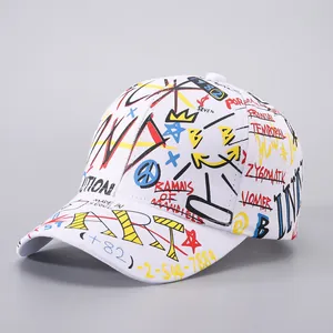Detail of white baseball cap featuring vibrant graffiti prints and creative ribbon accents