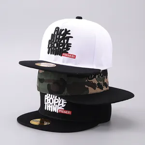 Detail of three hip-hop flat brim caps in white, camo, and black with 3D letter embroidery