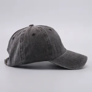 Detail view of washed cotton fabric texture and metal buckle on the dark grey baseball cap
