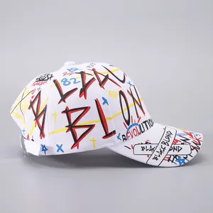 Close-up of street style graffiti print and black ribbon on a white cotton baseball cap