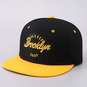 Detailed view of yellow 3D embroidery and twill cotton fabric on flat brim snapback cap