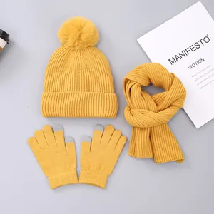 Detail of ginger yellow knit winter set featuring touchscreen gloves and pompom hat