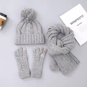 Detail of grey knitted winter set featuring thick cable knit and touchscreen glove tips