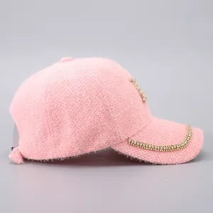 Detailaufnahme der rosa Pelz-Baseballkappe mit goldenen Strasssteinen und Metall-Logo