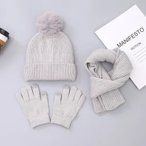 Three-piece winter knit set with grey pompom hat, warm scarf, and touchscreen gloves