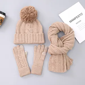 Detailed knit texture of winter hat scarf and gloves set with soft faux fur pom-pom