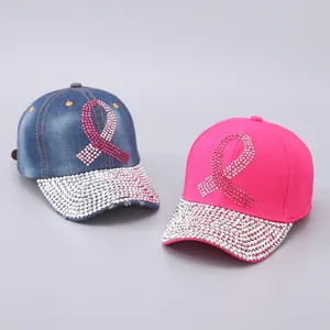 Close-up of sparkling pink ribbon rhinestone patterns and crystal-encrusted cap brims