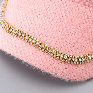 Nahaufnahme der rosa Nerzsamt-Baseballkappe mit drei Reihen bunter Strasssteine am Schirm