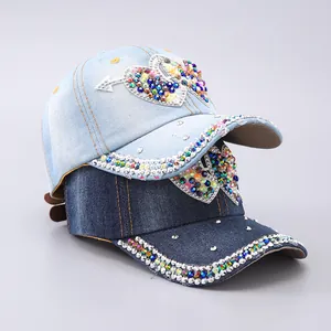 Detail of denim baseball caps featuring heart-shaped colorful rhinestone embellishments
