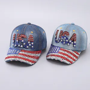 Dettaglio della scritta USA in strass e motivo bandiera USA su cappelli in denim lavato