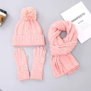 Pink cable knit winter set featuring a faux fur pompom hat, scarf, and touchscreen gloves