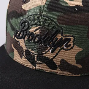 Detailed close-up of 3D Brooklyn embroidery on camouflage snapback baseball cap fabric