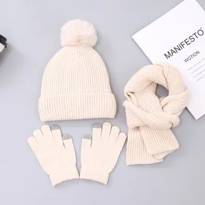 Detailed knit set with pom-pom beanie, scarf, and touchscreen gloves in creamy white