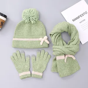 Detail van mintgroene winterse breiset met roze streeppatroon en bonten pompon