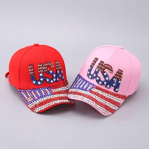 Close-up of USA rhinestone embroidery and flag patterns on red and pink baseball caps