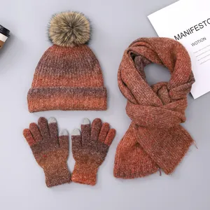 Detailed close-up of brown gradient tie-dye knitted set with pom-pom hat and touch-screen gloves