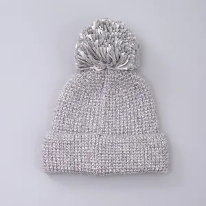 Detail of dark grey knit beanie with ribbed texture and mixed color faux fur pom-pom