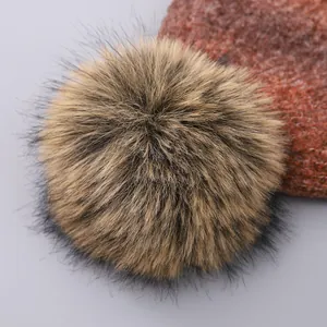 Close-up of premium faux fur pompom and soft cable knit texture on the winter hat