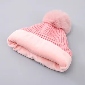 Detailed view of pink knitted toddler hat with fuzzy fleece lining and a faux fur pompom