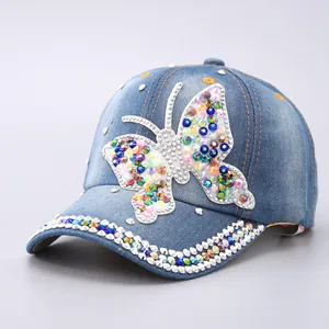 Washed denim baseball cap with colorful rhinestone butterfly and studded curved brim