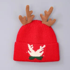 Detail van rode kerstmuts met pluchen bruine geweien en feestelijke gebreide kerstmotieven