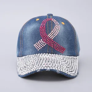 Detailed view of pink rhinestone ribbon and silver crystals on blue denim baseball cap