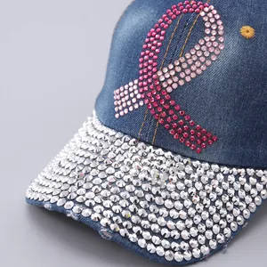 Detail of pink rhinestone ribbon and sparkling diamond brim on denim baseball cap