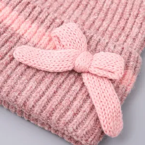Detailopname van het roze gebreide winteraccessoire met een grote getextureerde strik