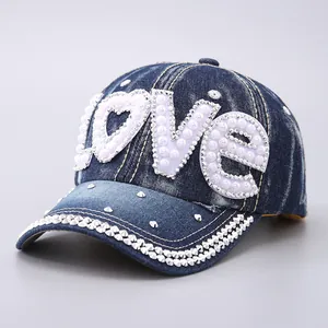 Detailed macro view of denim baseball cap with LOVE rhinestone and pearl embellishments