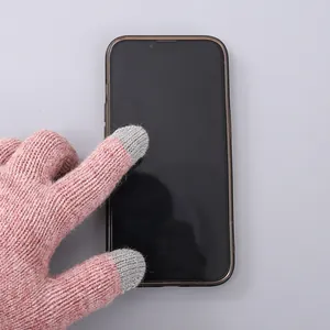 Close-up van roze gebreide handschoenen met touchscreenfunctie en grijze vingertoppen