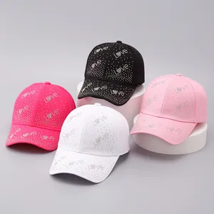 Dettaglio di quattro cappellini da baseball con motivo Love in strass in vari colori brillanti