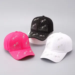 Dettaglio di tre cappellini da baseball con strass rosa nero e bianco motivo Love
