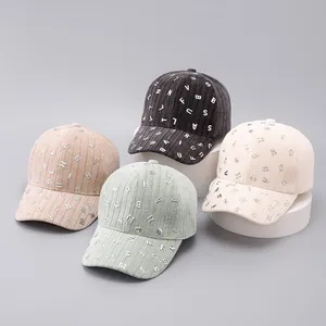 Detailed view of corduroy baseball caps with metallic letters in four pastel colors