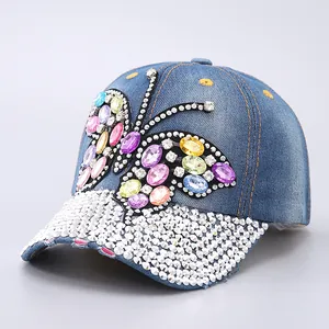 Detail of colorful rhinestone butterfly and crystal brim on navy denim baseball cap