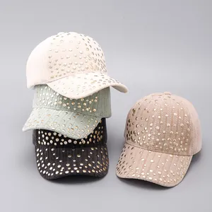 Close-up of four corduroy baseball caps in pastel colors with gold rivet decorations