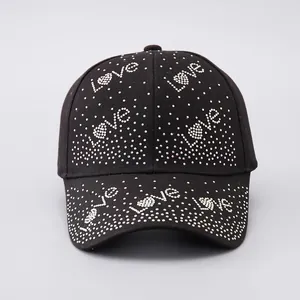 Dettaglio di strass argento che formano il motivo Love su cappello nero in cotone