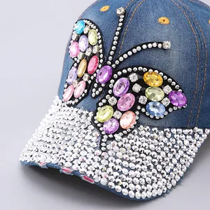 Close-up of denim baseball cap featuring colorful rhinestone butterfly and star embroidery