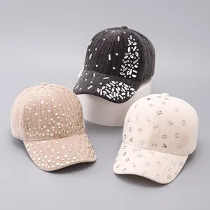 Detailed view of corduroy baseball caps with rhinestones, metal studs and letters