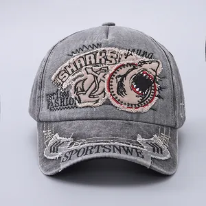 Detailed view of washed grey baseball cap with shark patch and vintage distressed embroidery