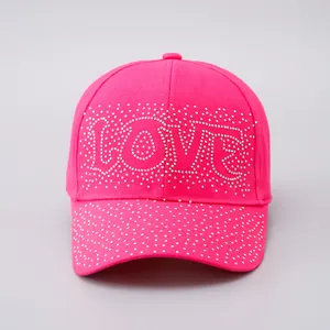 Dettaglio della scritta LOVE in strass scintillanti su un cappellino rosa acceso